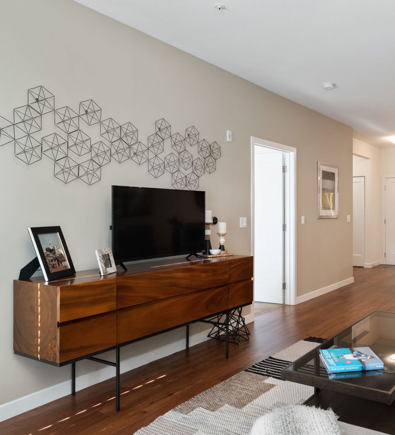 Domain City Center Interior of a living room featuring a couch, coffee table, and television.