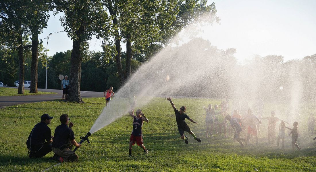 Domain City Center Scenic shot of a water spray in the park and kids playing under it in Lenexa, USA