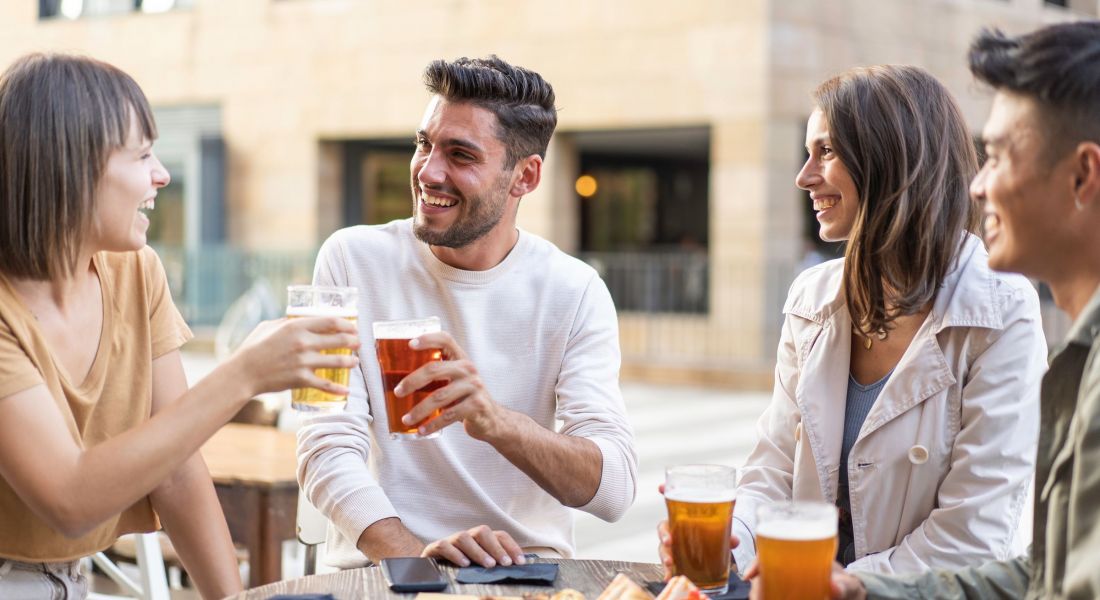 Domain City Center Happy friends drinking beer at the outdoor pub in the city - Friendship lifestyle concept with young millennial people enjoying time together at open air pub