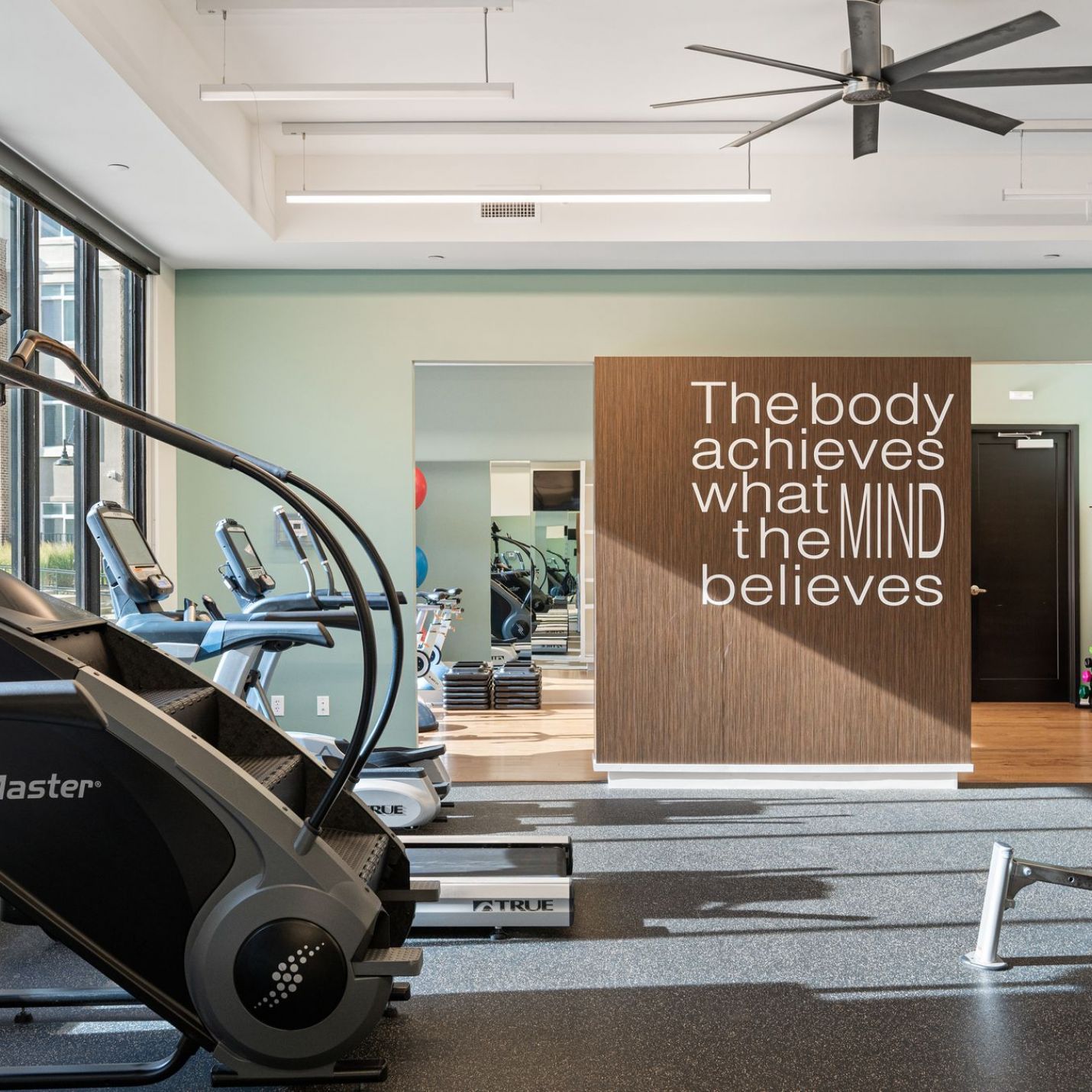 Domain City Center Gym with treadmill, exercise bike, and ceiling fan.